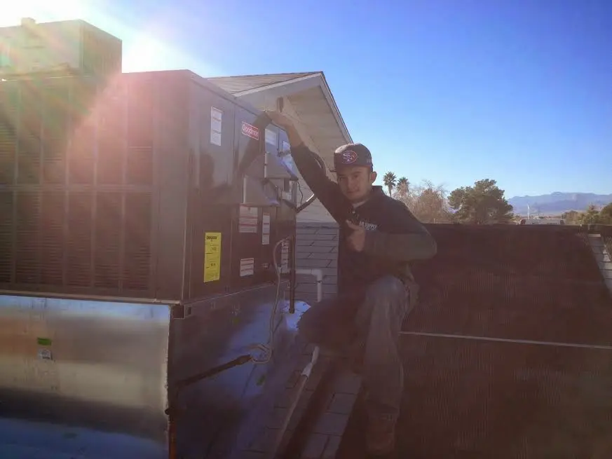 HVAC technician performing AC Tune-Up on a rooftop unit in Palmetto